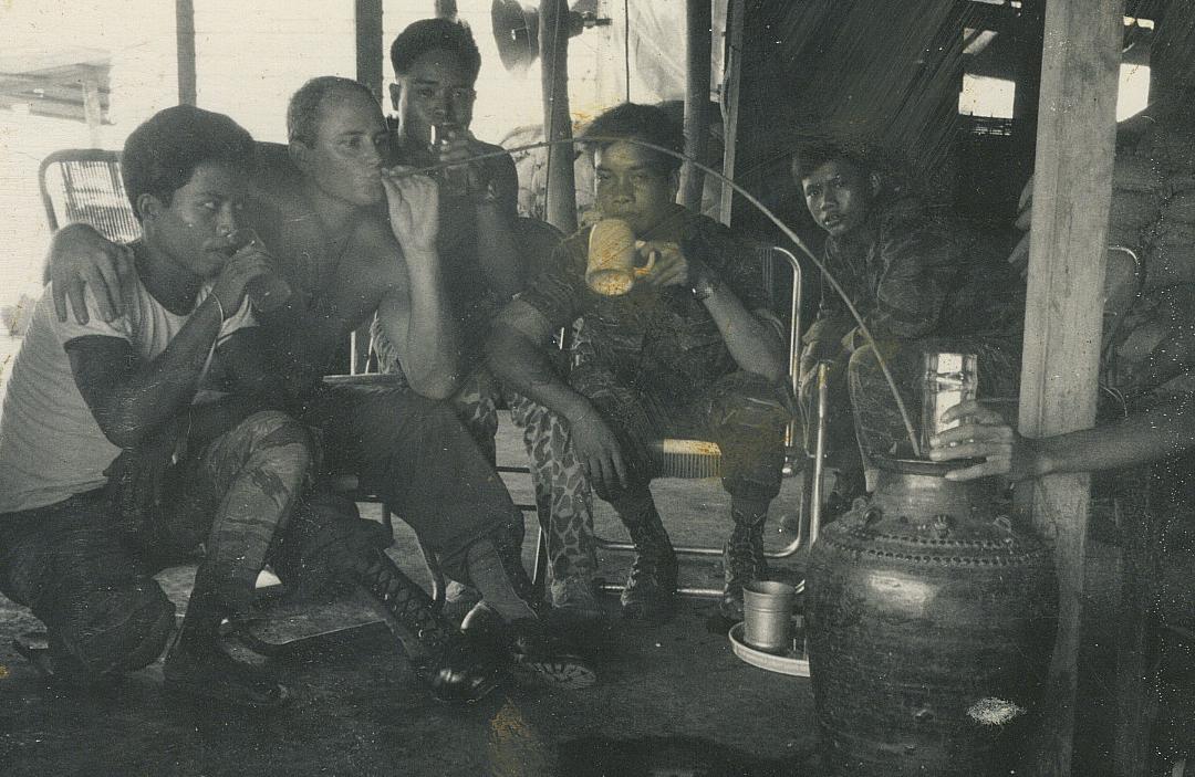 SSG Lonny Holmes drinking rice wine with the \'Montagnards, Plei Djereng, A-251 July 68. It gives you a very bad hangover.