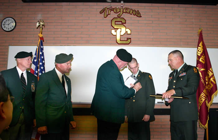 University of Southern California Trojan Battalion LTC Robert F. Huntly, Commanding, to right. Jim Duffy pinning Special Forces Medal of Merit on USC ROTC Cadet Mark Thomas. Lonny Holmes and Len Fein on left.