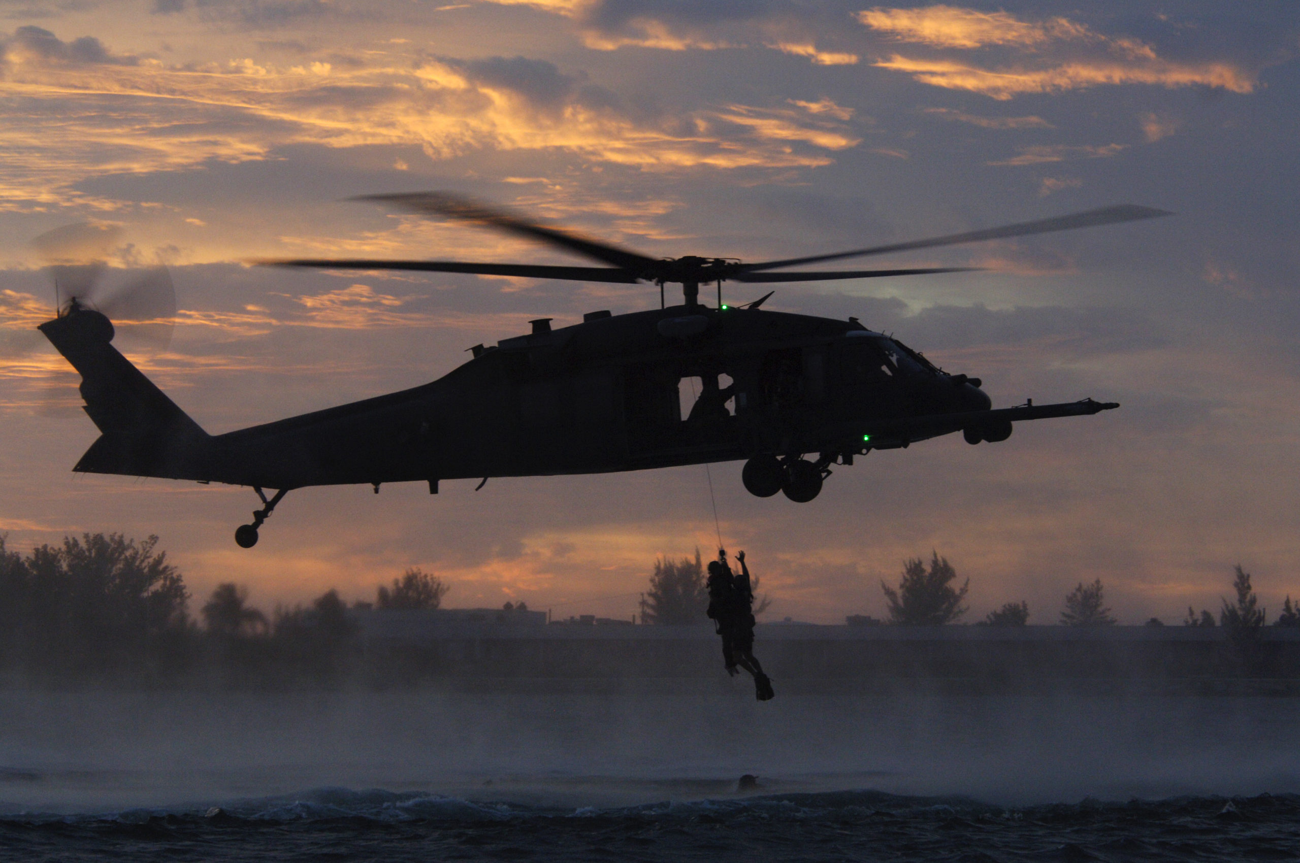 Alex Quade dangling from helicopter with AFSOC PJs. (Photographer, Greg Danilenko, courtesy Alex Quade)
