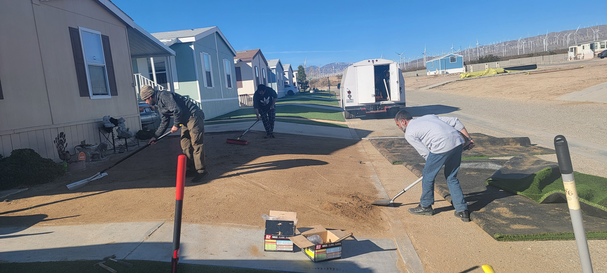 Community members at work preparing the ground for artificial turf.