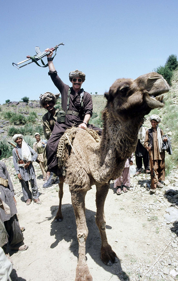Brown on camel in Afghanistan. The AK is not a prop.(Photo by Jim Coyne)